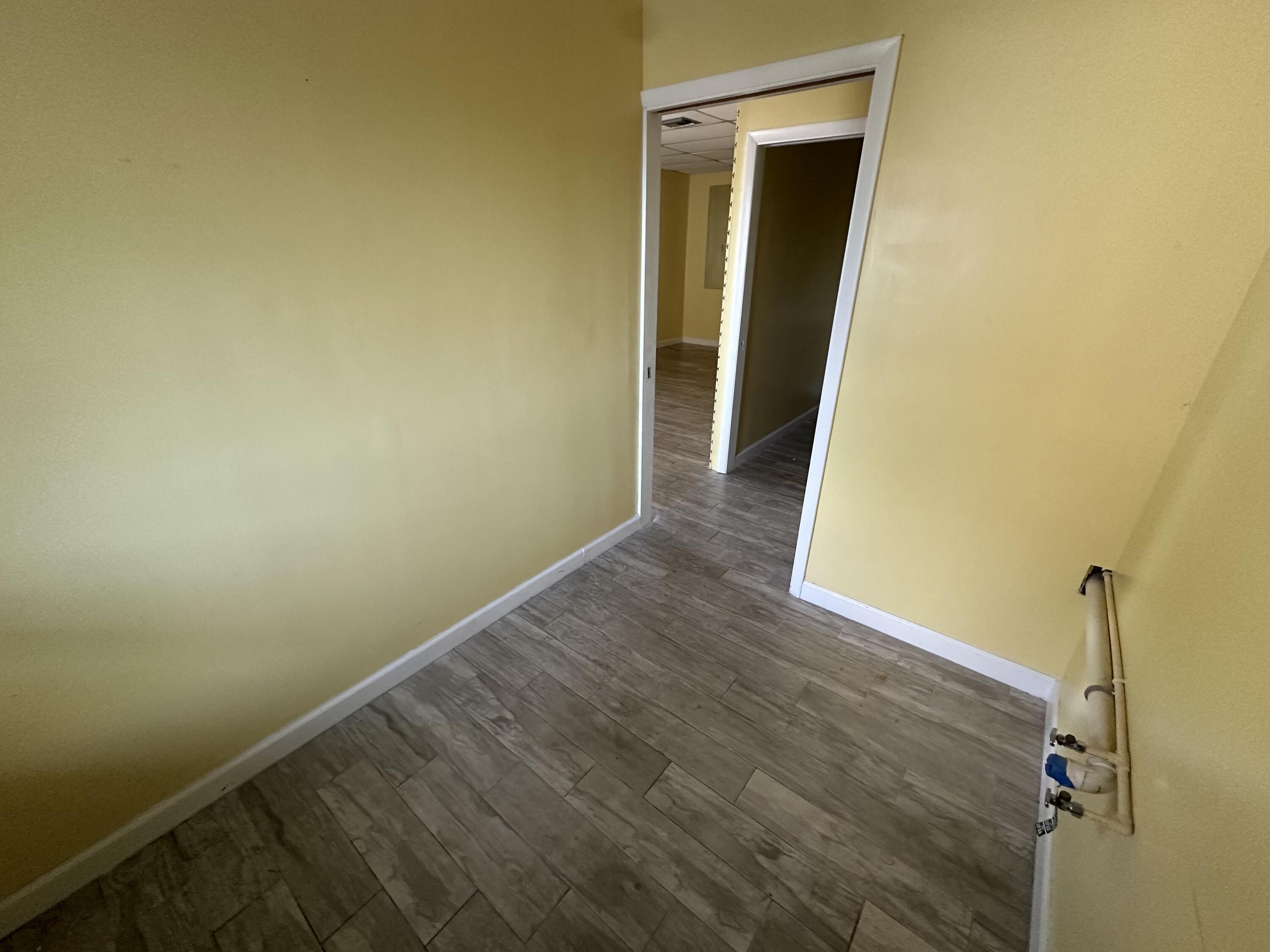 705 Park Avenue, Unit A Lake Park, FL 33403 - Photo 11 of 28 a view of a room with wooden floor and a wall