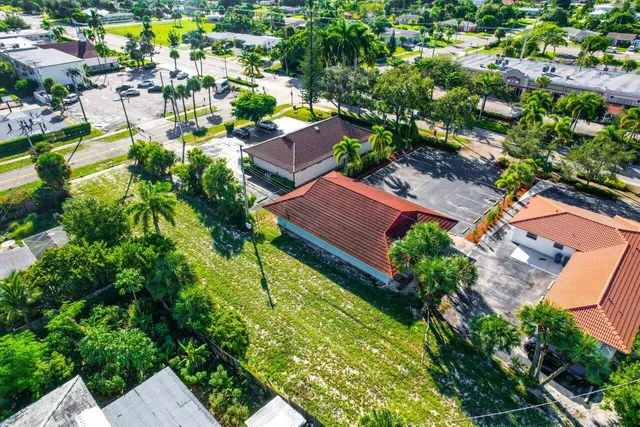 an aerial view of residential houses with outdoor space and trees