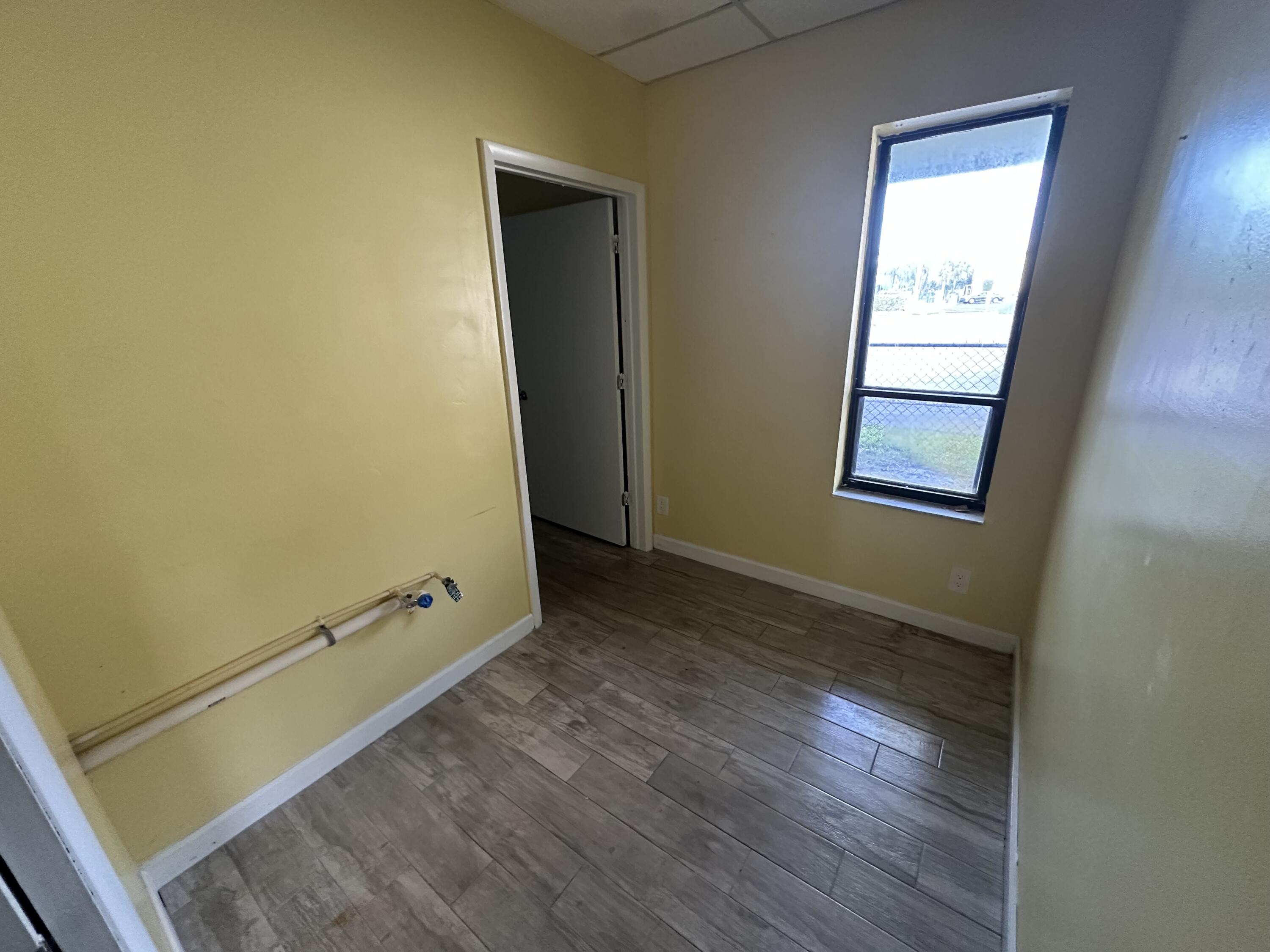 705 Park Avenue, Unit A Lake Park, FL 33403 - Photo 10 of 28 a view of room with window and wooden floor