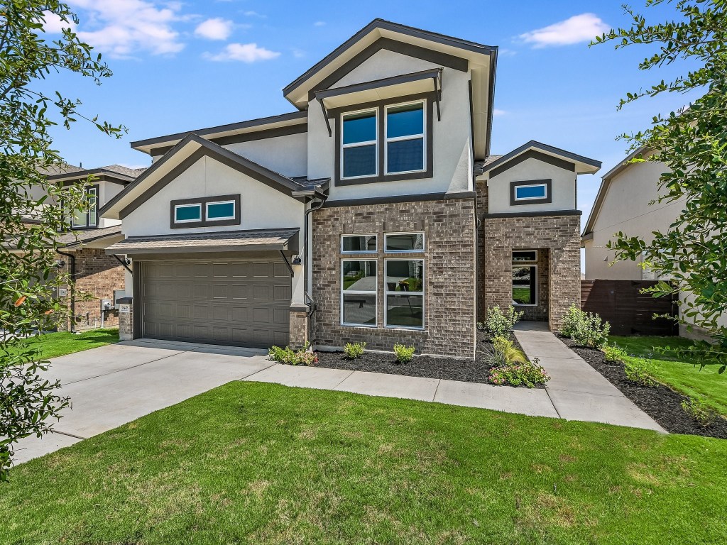 a front view of a house with a yard and garage