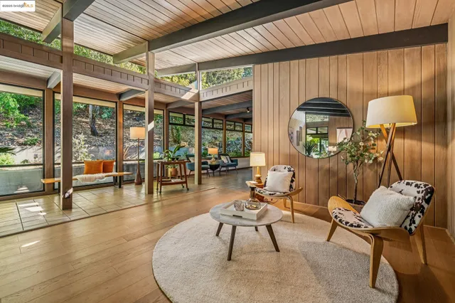 a dining room with furniture and large windows