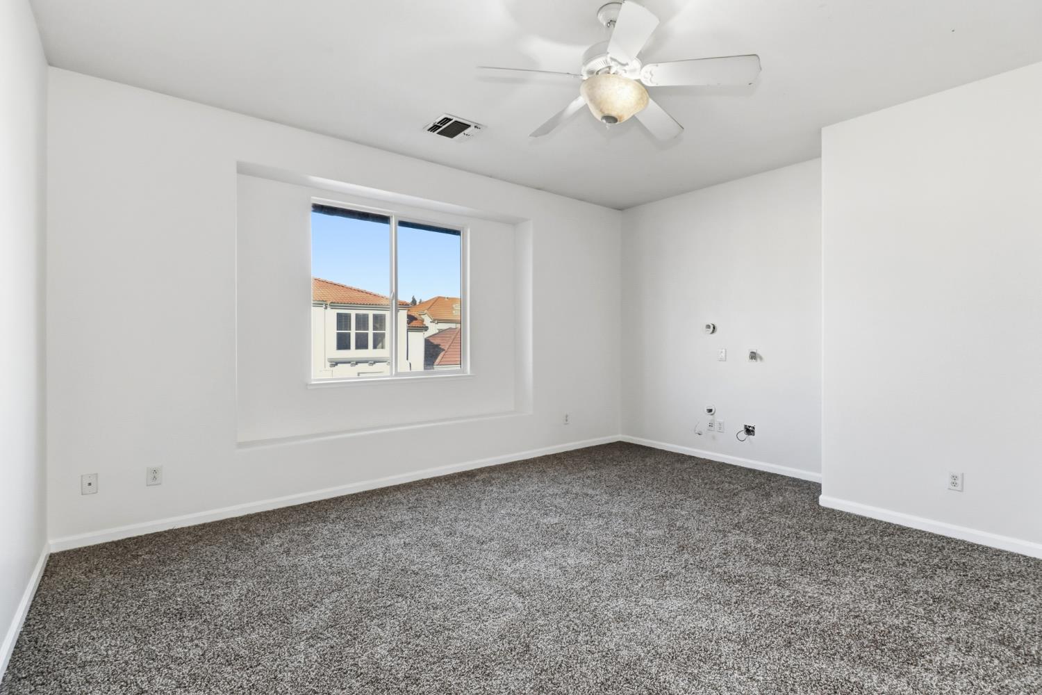 11832 Stoney Ridge Way Rancho Cordova, CA 95742 - Photo 16 of 44 an empty room with a chandelier fan and windows
