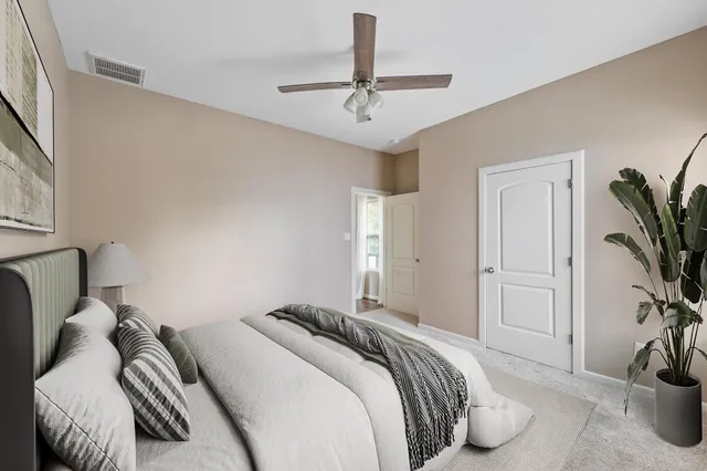 a bedroom with a bed and a potted plant