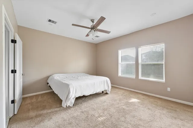 a spacious bedroom with a bed and window