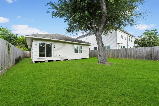 a view of a house with backyard and a tree