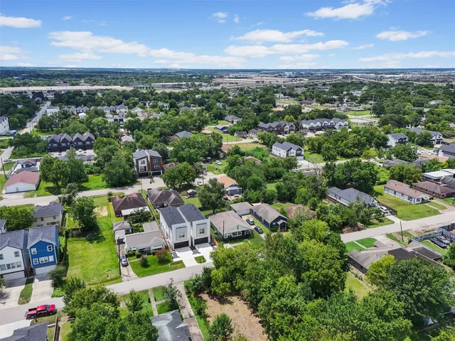 an aerial view of residential houses with outdoor space and trees