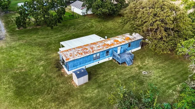 an aerial view of a house with a yard table and chairs