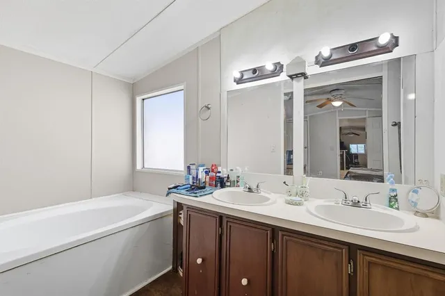 a bathroom with a double vanity sink mirror double and bathtub