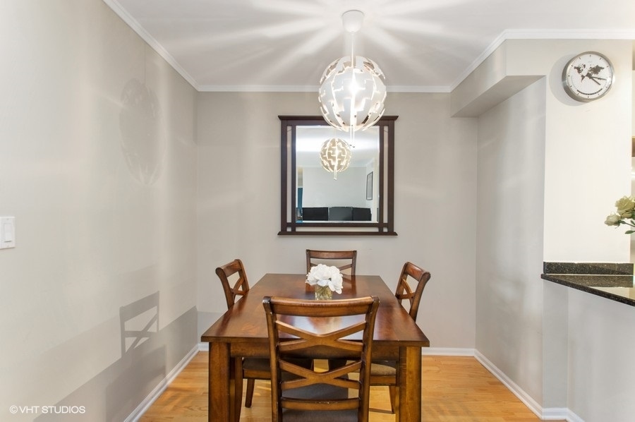 6102 North Sheridan Road, Unit 410 Chicago, IL 60660 - Photo 12 of 12 a dining room with furniture and chandelier