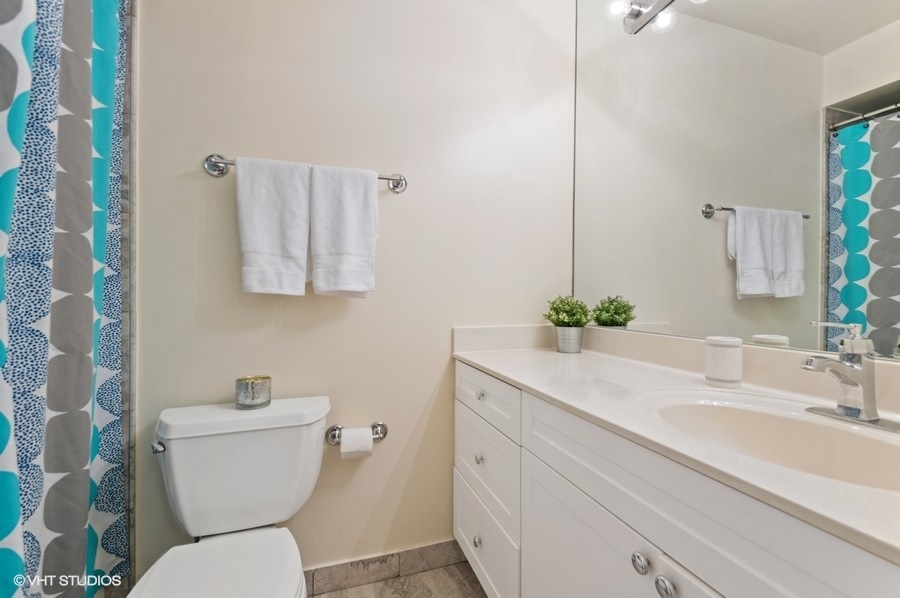 6102 North Sheridan Road, Unit 410 Chicago, IL 60660 - Photo 5 of 12 a bathroom with a toilet sink and mirror
