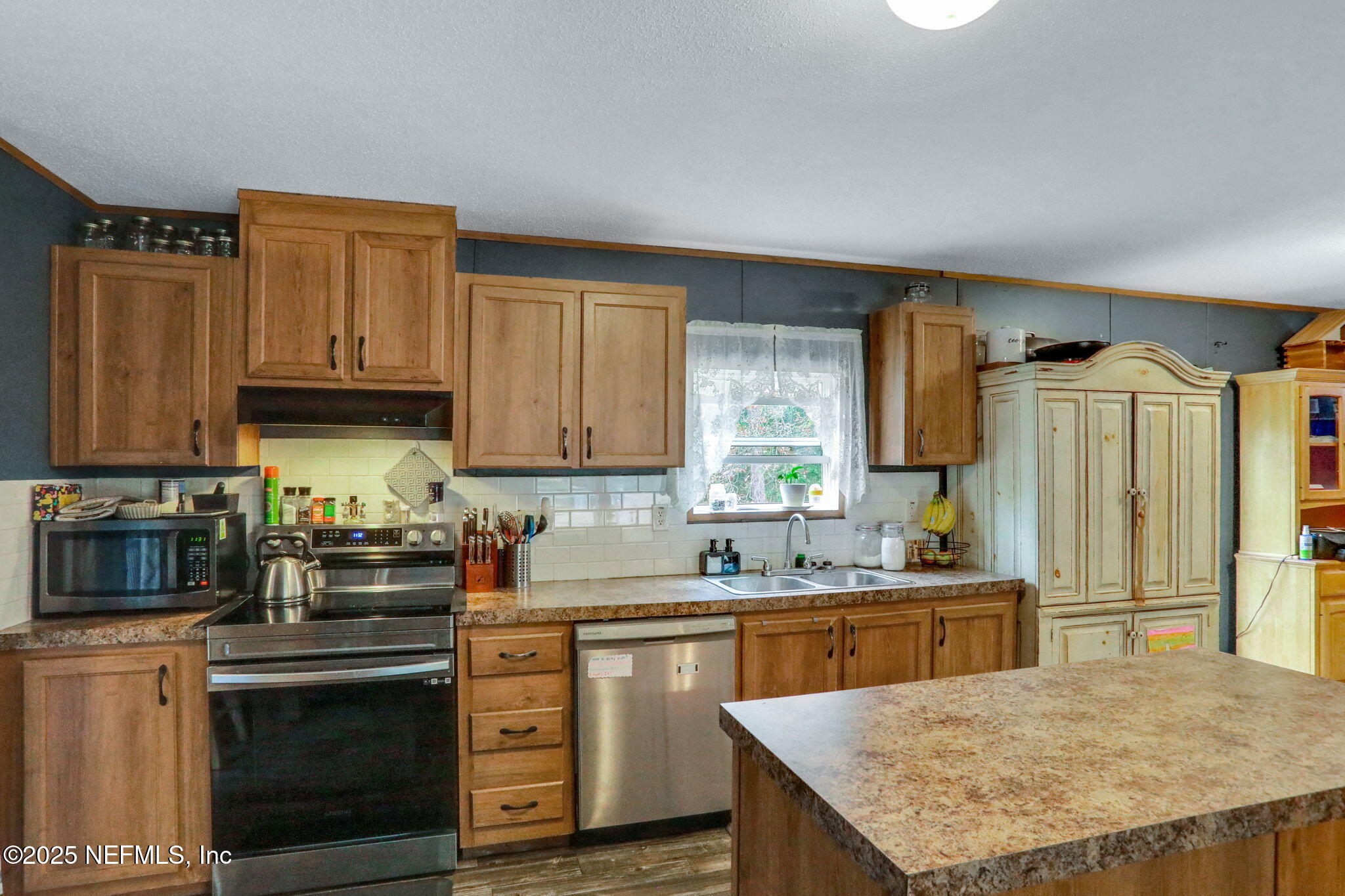 4527 Bondarenko Road Keystone Heights, FL 32656 - Photo 26 of 56 a kitchen with stainless steel appliances granite countertop a sink stove and refrigerator