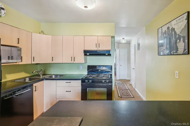 a kitchen with granite countertop a stove a sink and a refrigerator