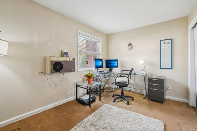 a view of a workspace with furniture and a window