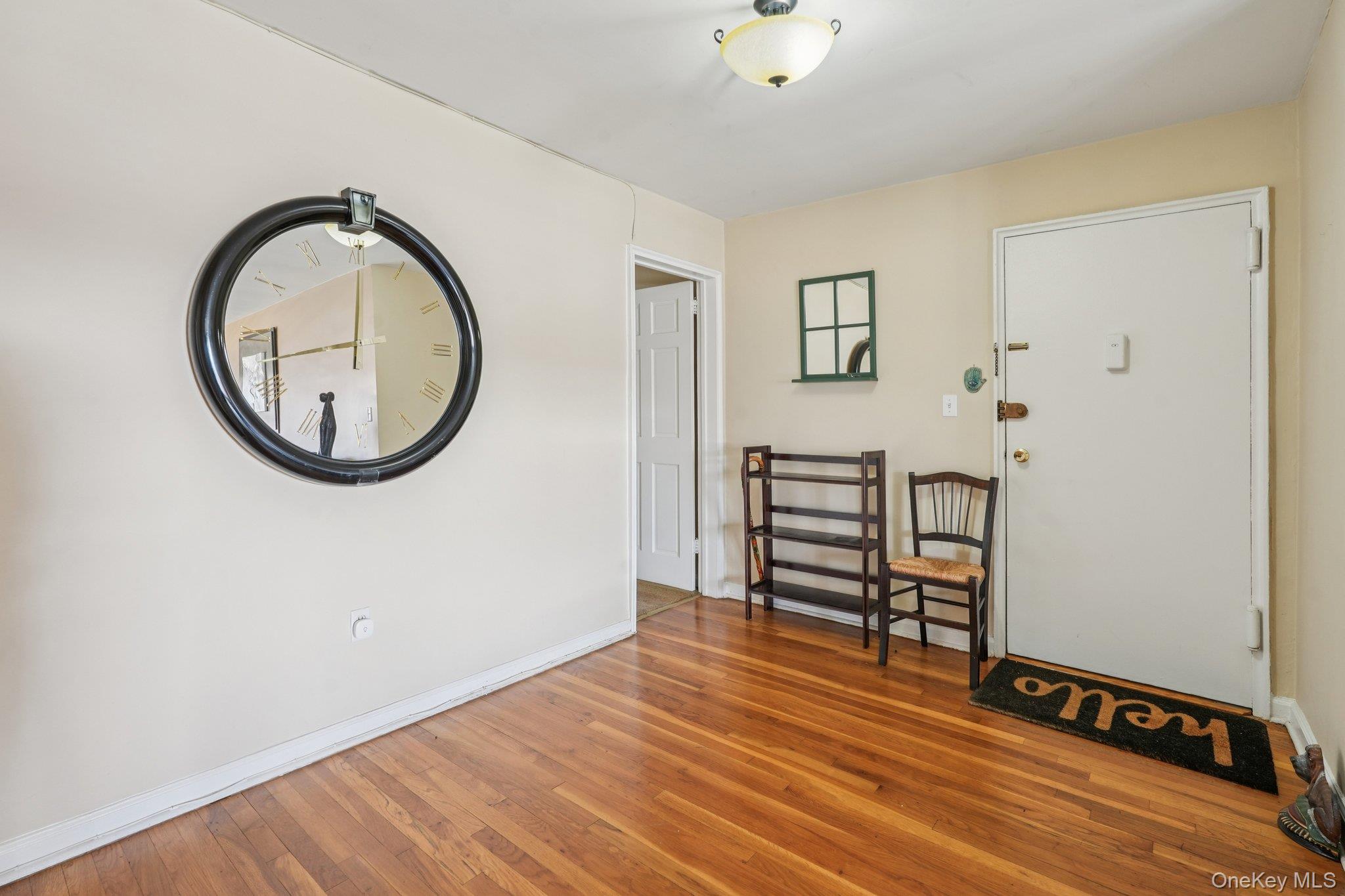57 Maple Avenue, Unit 2B Hastings-on-Hudson, NY 10706 - Photo 29 of 38 an empty room with mirror and a wooden floor