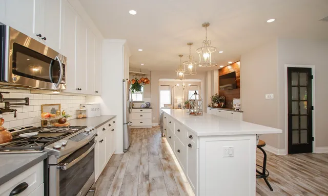 a kitchen with a sink a stove a refrigerator and cabinets