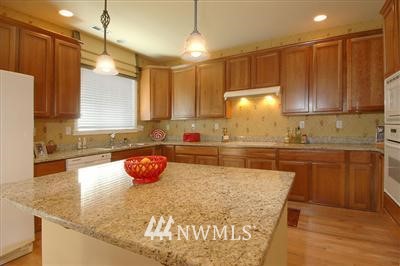25527 Southeast 275th Place Maple Valley, WA 98038 - Photo 7 of 20 a kitchen with granite countertop a stove a sink and a refrigerator
