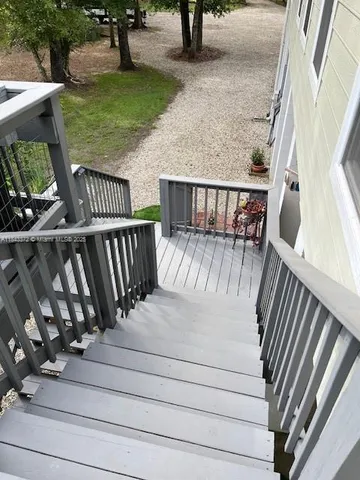 a balcony with wooden floor stairs and furniture