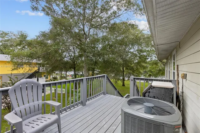 a balcony with wooden floor and outdoor seating