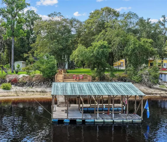 a view of a patio with table and chairs with wooden floor and fence