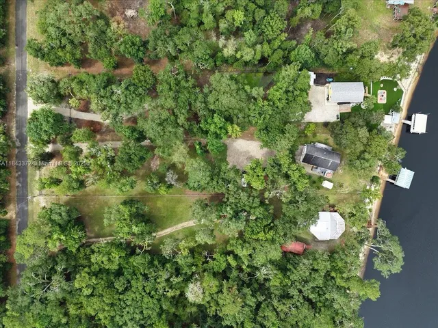 an aerial view of a house with a yard and garden in the back