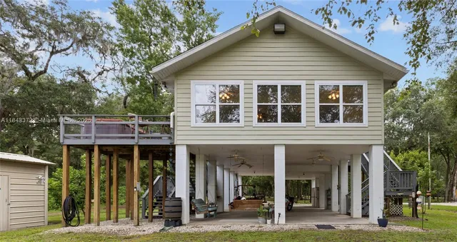 a front view of a house with glass windows and a yard