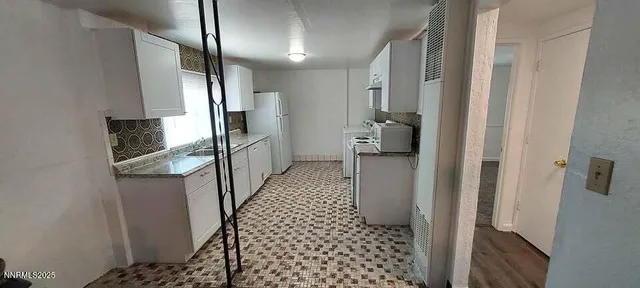 a kitchen with granite countertop a refrigerator and a sink