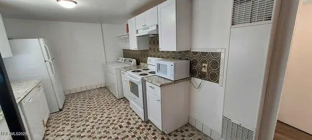a kitchen with a stove a refrigerator and cabinets