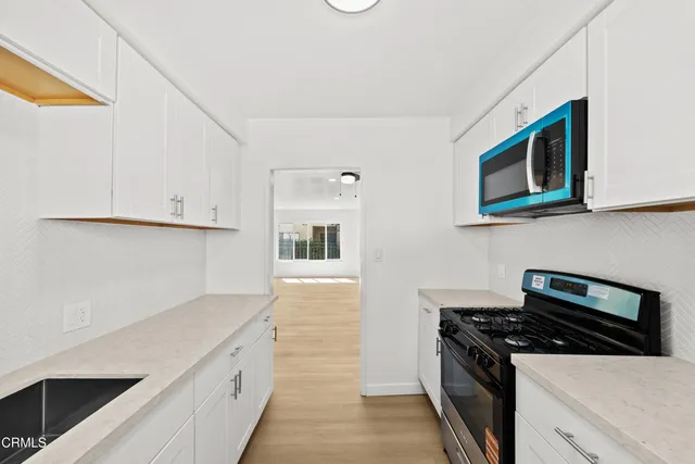 a kitchen with stainless steel appliances a stove microwave and cabinets
