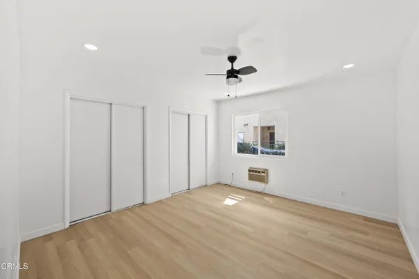 a view of empty room with wooden floor and cabinet