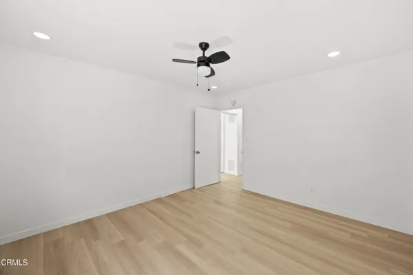 a view of a room with wooden floor and ceiling fan