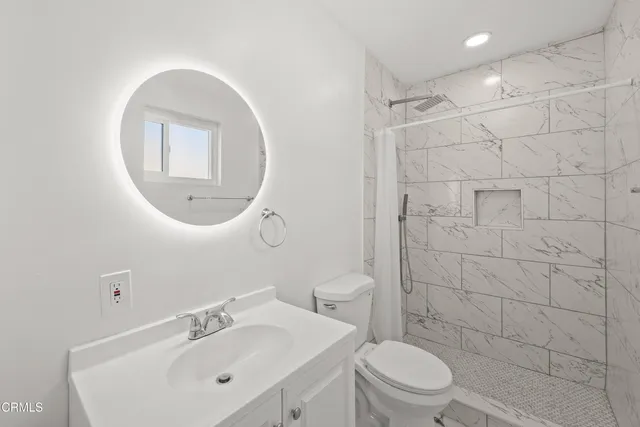 a bathroom with a sink a toilet and a mirror