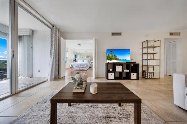 a living room with furniture a rug and a large window