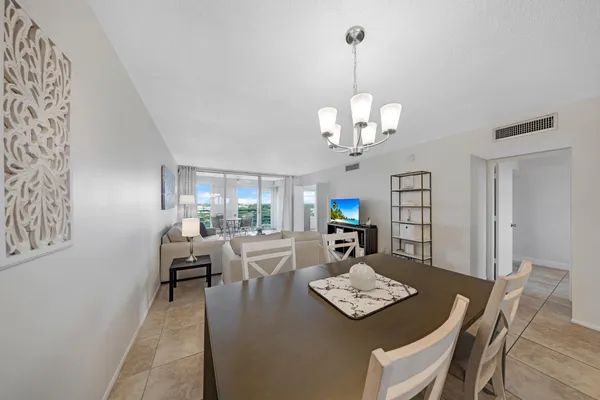 a view of a dining room with furniture a chandelier and wooden floor