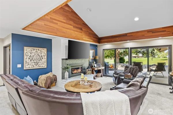 a living room with furniture a large window and a flat screen tv
