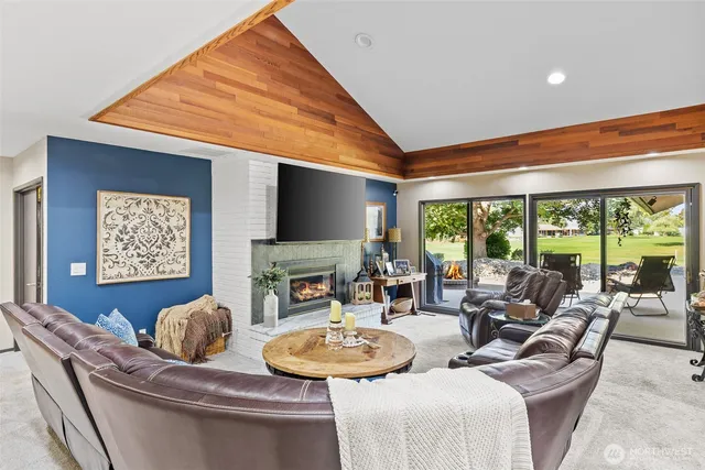 a living room with furniture a large window and a flat screen tv