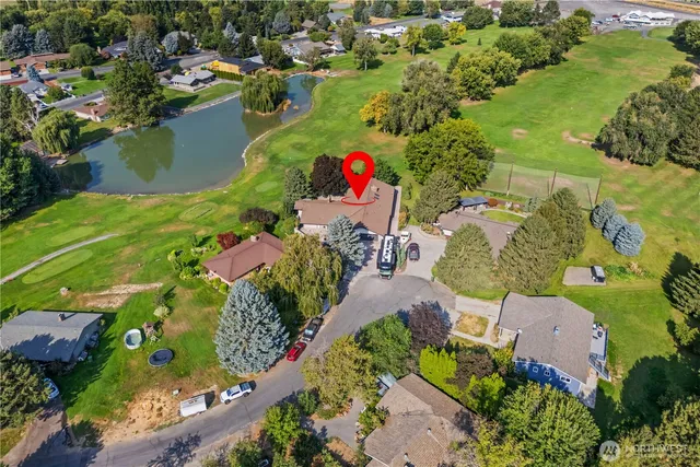 an aerial view of a house with a yard and lake view