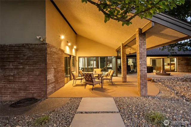 a view of a patio with table and chairs with wooden fence