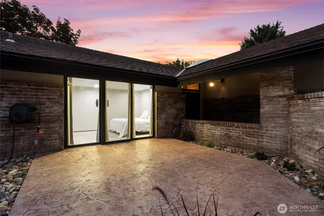 a view of an empty room with a fireplace and wooden floor