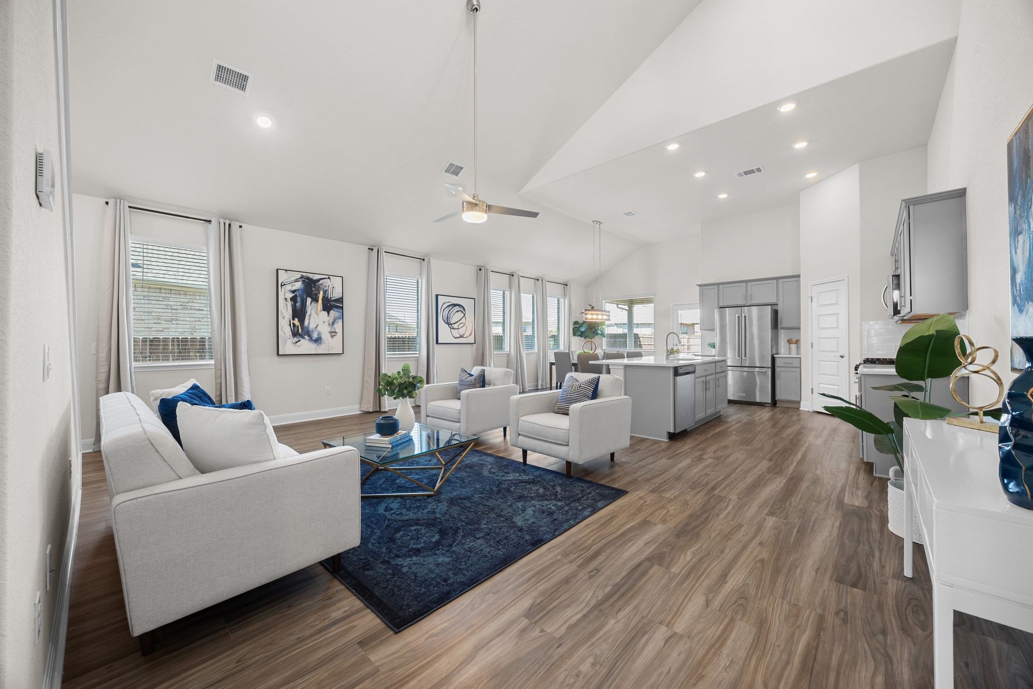 Living area featuring recessed lighting, high vaulted ceiling, dark wood-style floors, and a ceiling fan