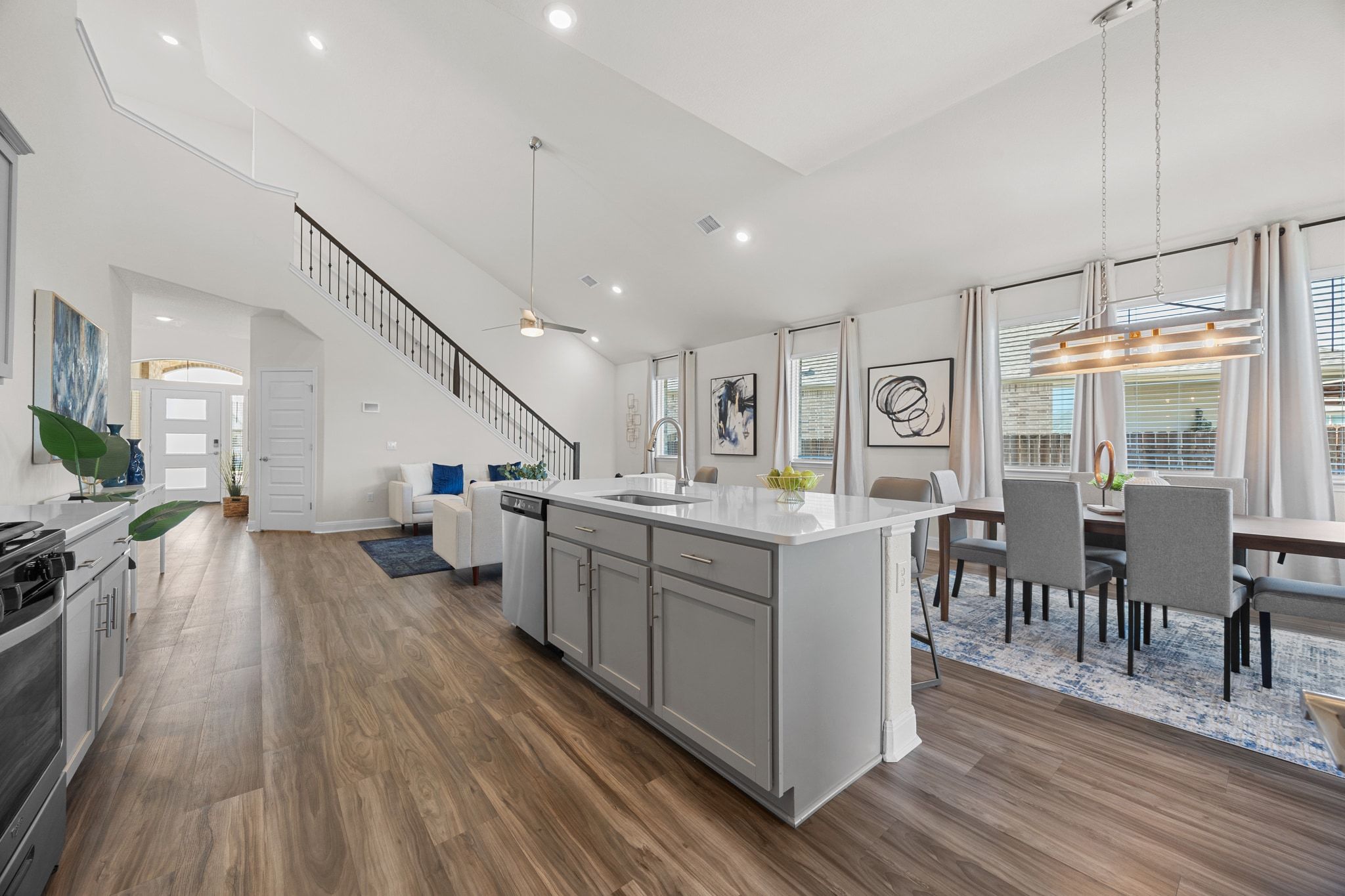 16804 Guido Cove Pflugerville, TX 78660 - Photo 38 of 38 Kitchen featuring gray cabinets, open floor plan, ceiling fan, high vaulted ceiling, and a center island with sink