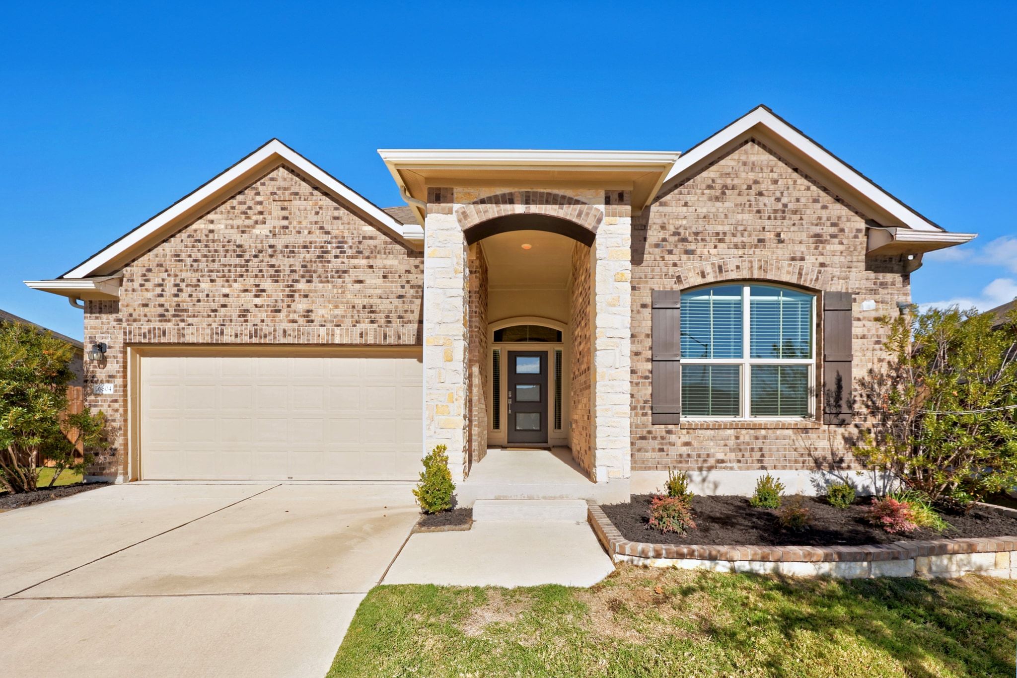 16804 Guido Cove Pflugerville, TX 78660 - Photo 2 of 38 View of front facade featuring brick siding, an attached garage, and concrete driveway