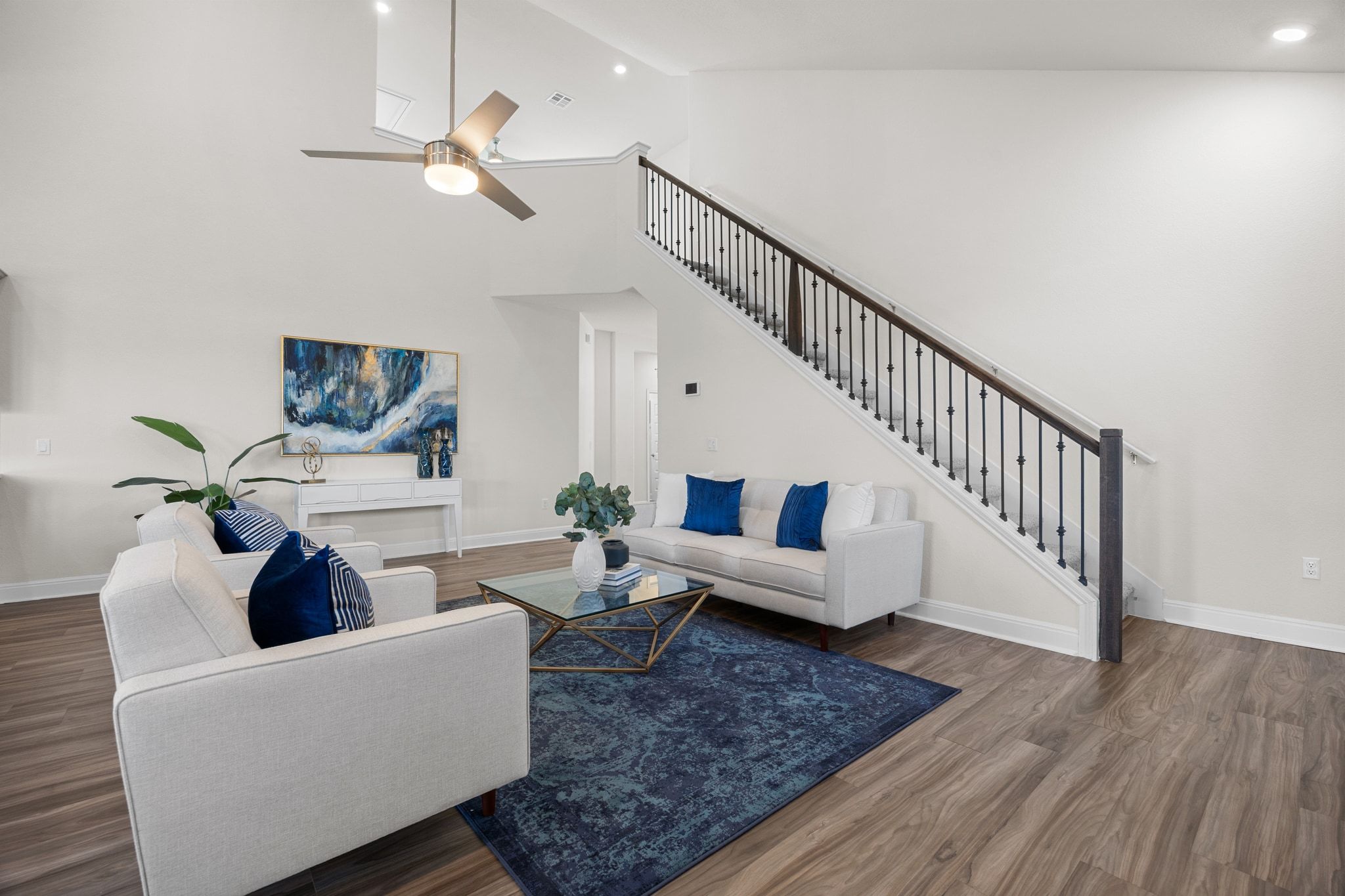 16804 Guido Cove Pflugerville, TX 78660 - Photo 7 of 38 Living room with stairs, wood finished floors, high vaulted ceiling, ceiling fan, and recessed lighting
