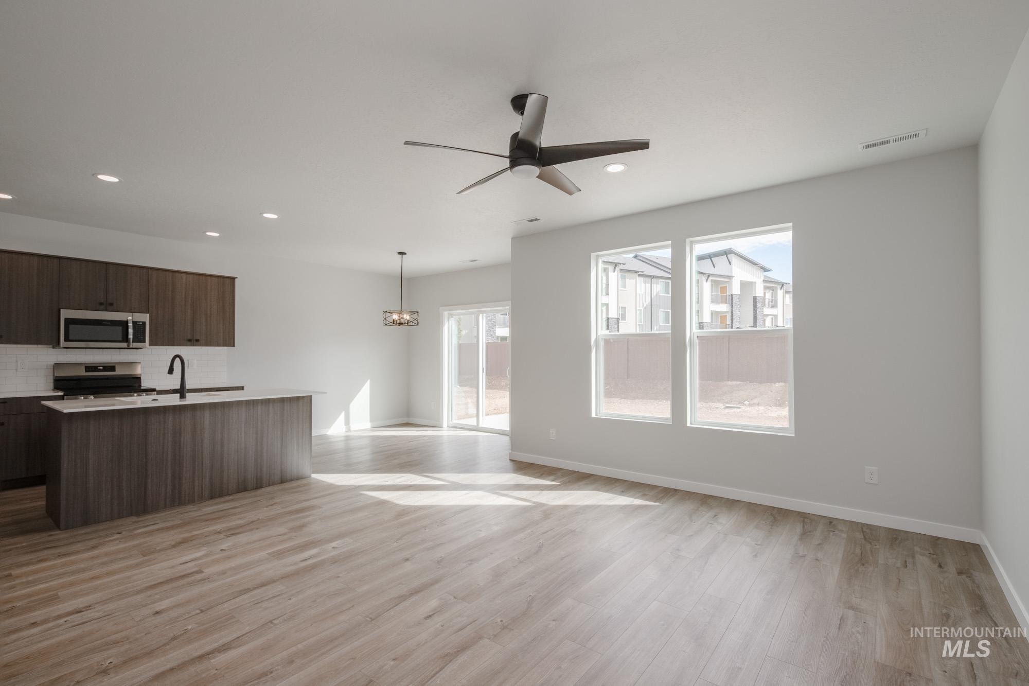 2192 South Border Way Meridian, ID 83642 - Photo 20 of 22 Kitchen with a ceiling fan, a center island with sink, stainless steel appliances, hanging light fixtures, and open floor plan