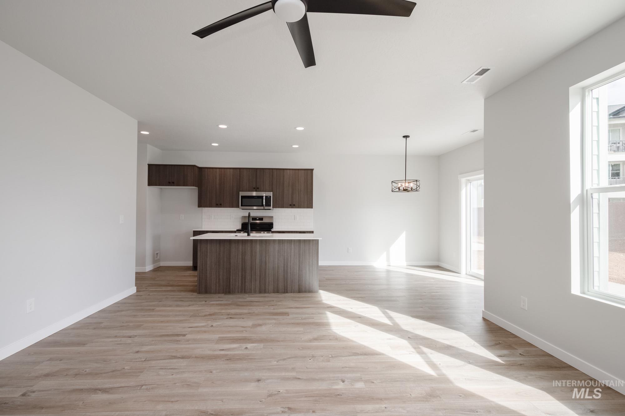 2192 South Border Way Meridian, ID 83642 - Photo 21 of 22 Kitchen featuring a kitchen island with sink, open floor plan, and light wood-style floors