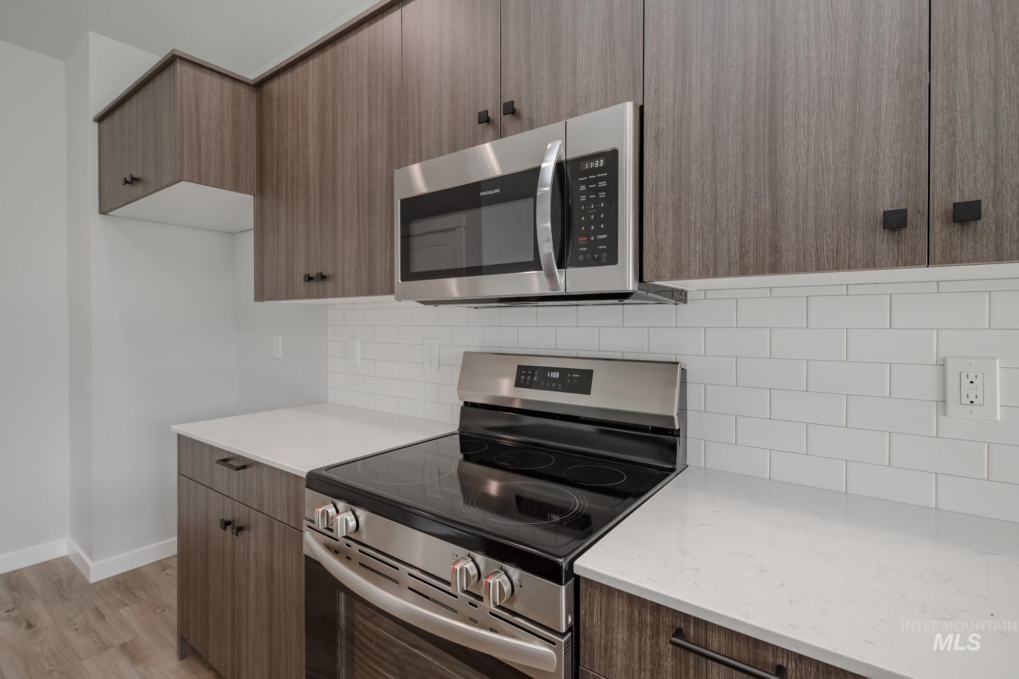 2192 South Border Way Meridian, ID 83642 - Photo 6 of 22 Kitchen featuring stainless steel appliances, tasteful backsplash, modern cabinets, light stone countertops, and light wood finished floors