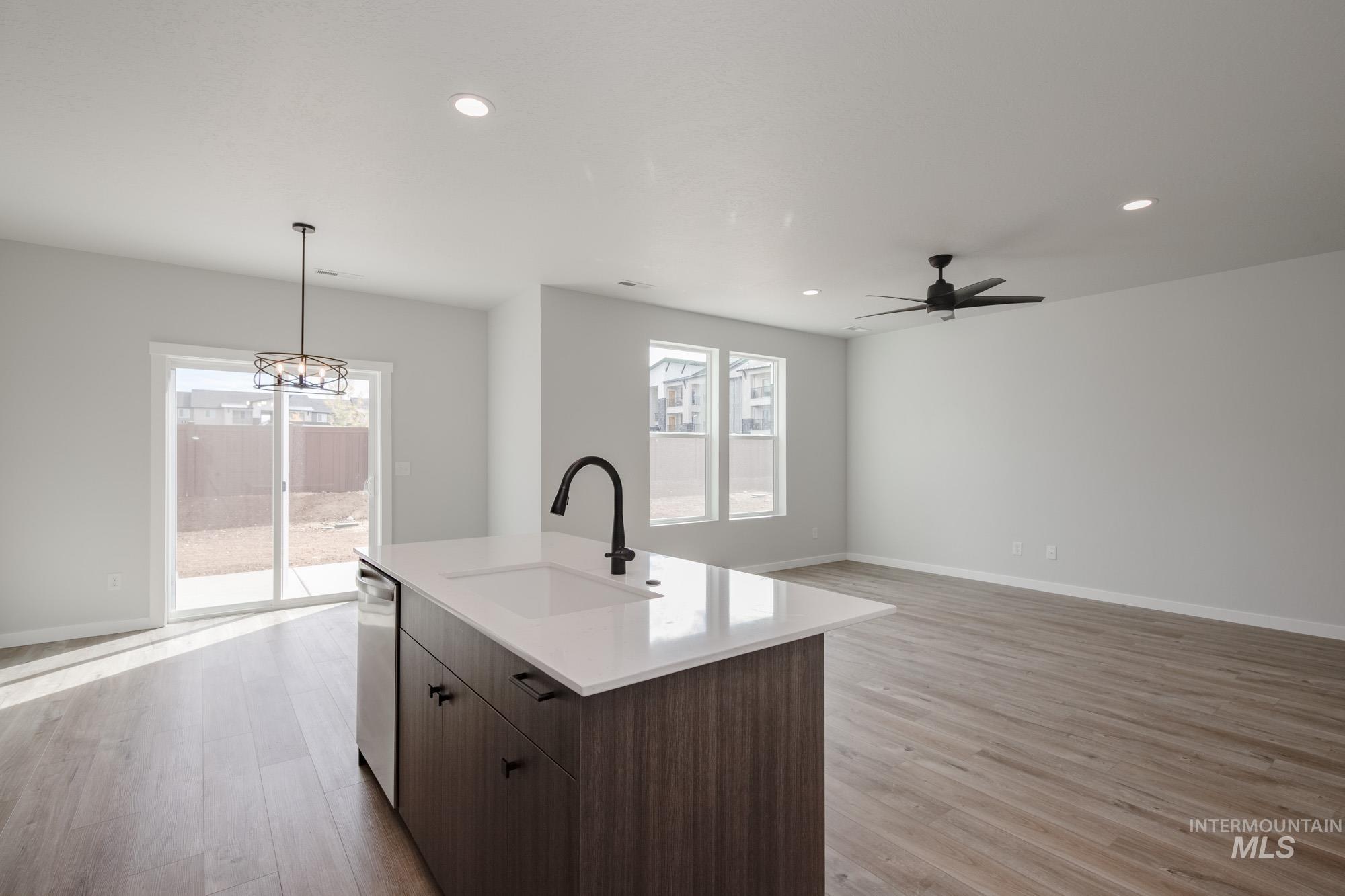 2192 South Border Way Meridian, ID 83642 - Photo 19 of 22 Kitchen with dark wood finish cabinets, light wood-style floors, open floor plan, and healthy amount of natural light