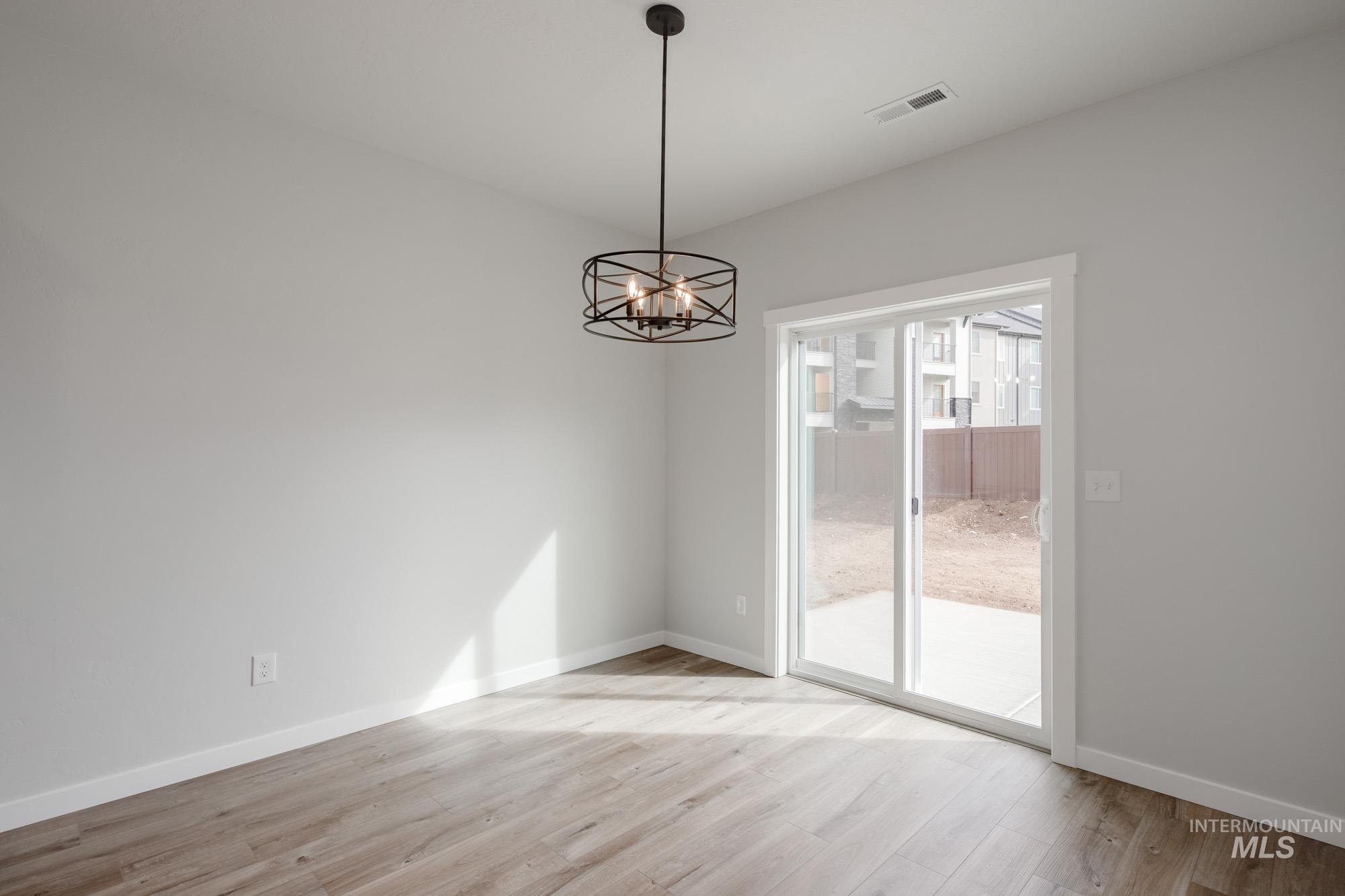 2192 South Border Way Meridian, ID 83642 - Photo 7 of 22 Unfurnished dining area featuring light wood-style flooring and hanging lights