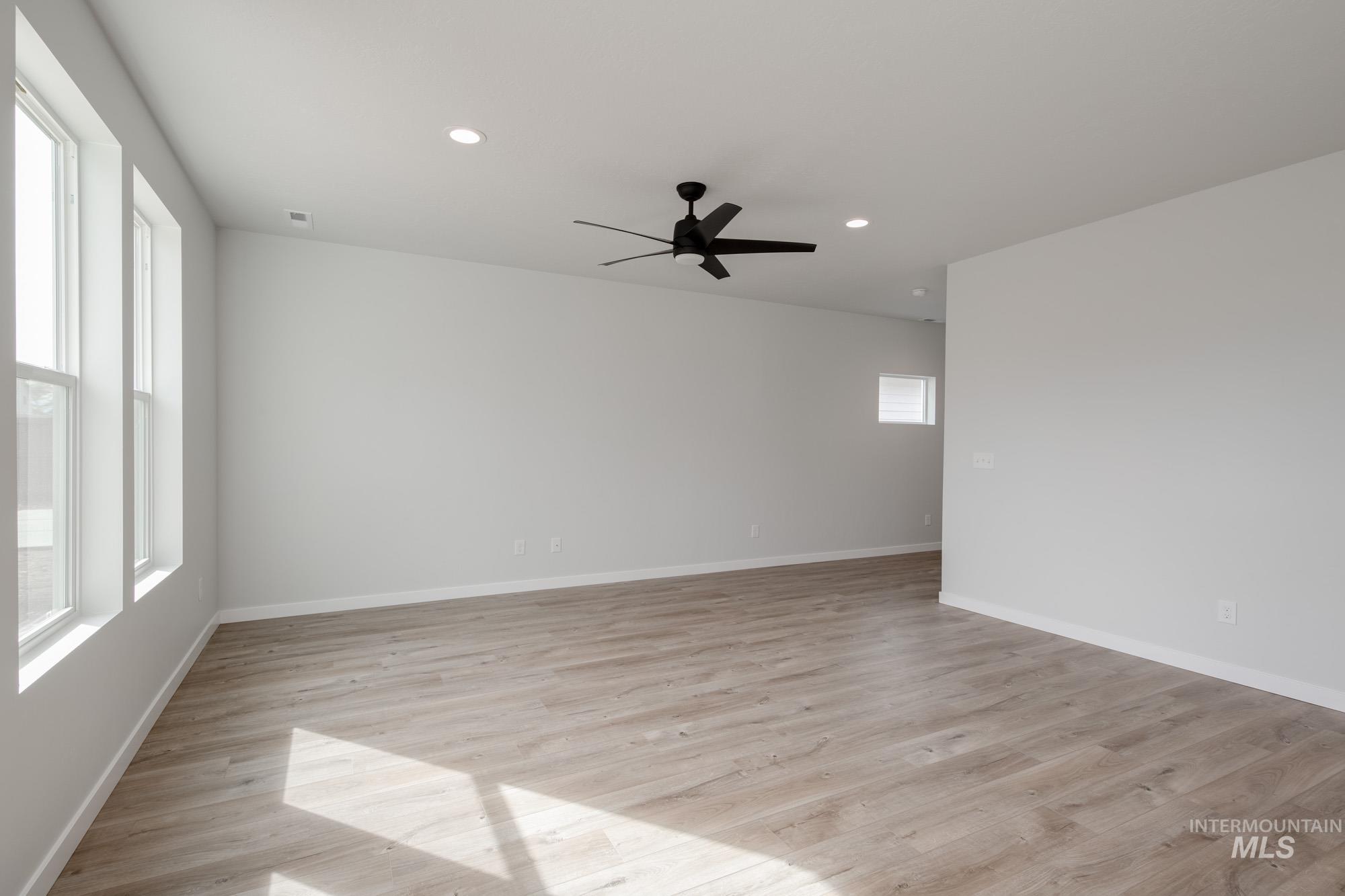 2192 South Border Way Meridian, ID 83642 - Photo 8 of 22 Spare room with ceiling fan, light wood finished floors, healthy amount of natural light, and recessed lighting