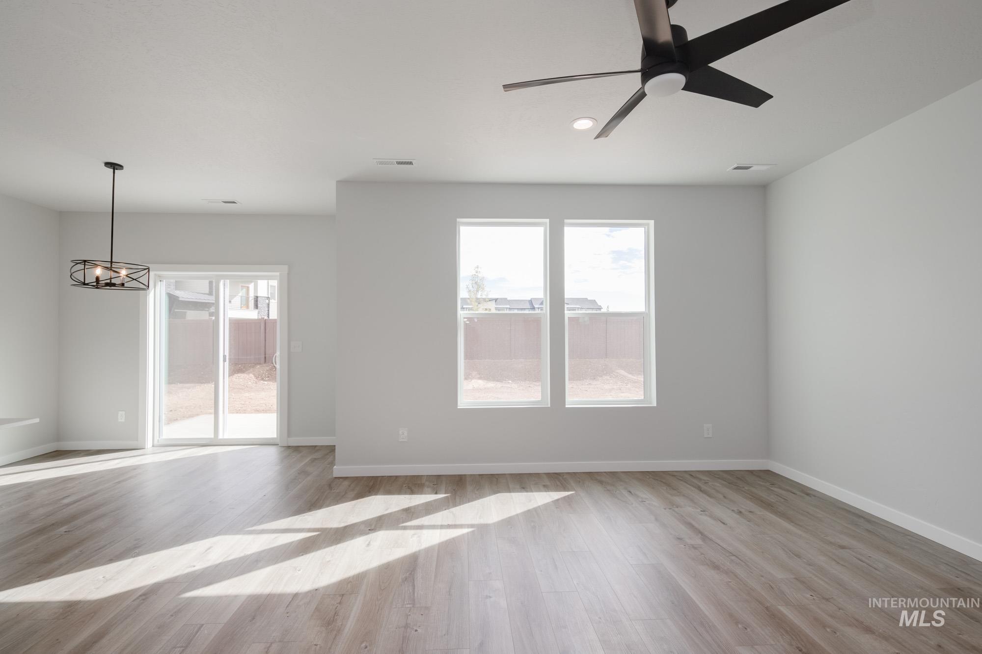 2192 South Border Way Meridian, ID 83642 - Photo 9 of 22 Unfurnished room with ceiling fan, light wood-style flooring, plenty of natural light, and suspended lighting