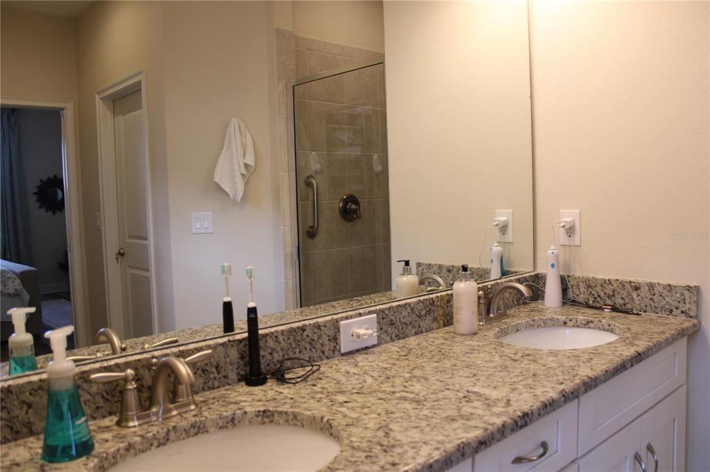 13711 Messina Loop, Unit 104 Bradenton, FL 34211 - Photo 22 of 70 a bathroom with a granite countertop sink and a mirror